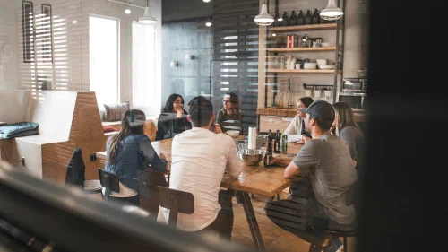 A small team gathered around a table in a bright, informal workspace